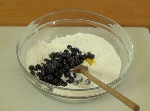 adding blueberries and lemon zest to mixing bowl