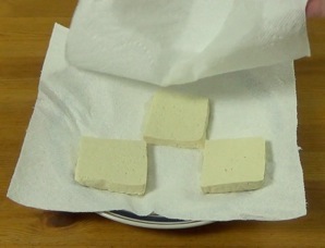 pressing the tofu between paper towels