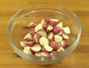 Quartered red new potatoes in a bowl