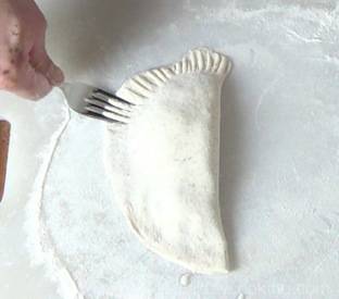 sealing the pastry with a fork