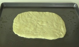 shaping dough into a rectangle on the baking sheet
