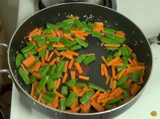 stir frying the carrots and sugarsnap peas