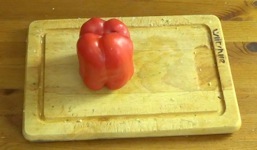 putting a red pepper on its head on a cutting board