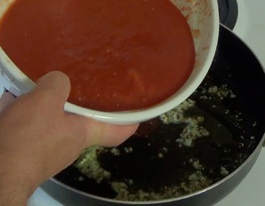 pouring tomato mixture into pan